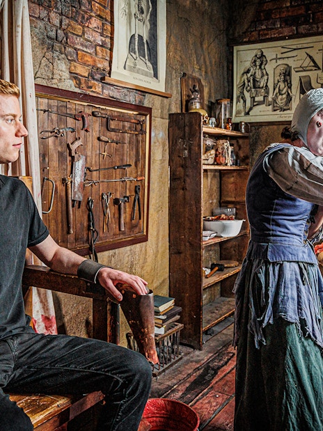 London Dungeon Torture Chamber exhibit with medieval torture devices and dimly lit stone walls.