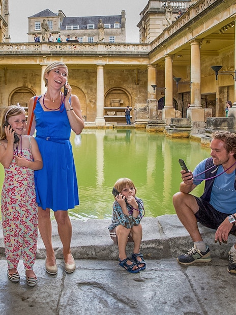 Tourists at Stonehenge with Windsor Castle, Bath, and Roman Baths day trip from London.