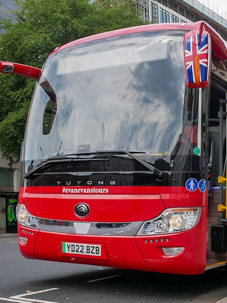 Stonehenge, Windsor Castle, and Bath day trip coach parked near London street.