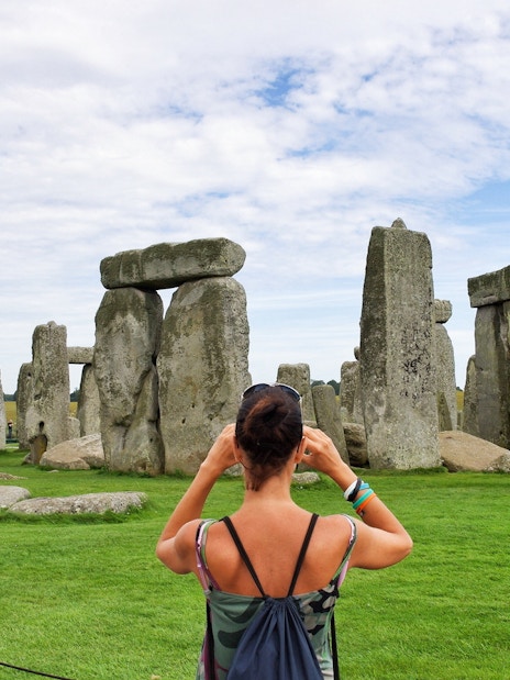 Woman photographing Stonehenge in Wiltshire, England.