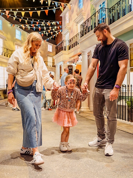 Children interacting with Paddington Bear statue at The Paddington Bear Experience, London.