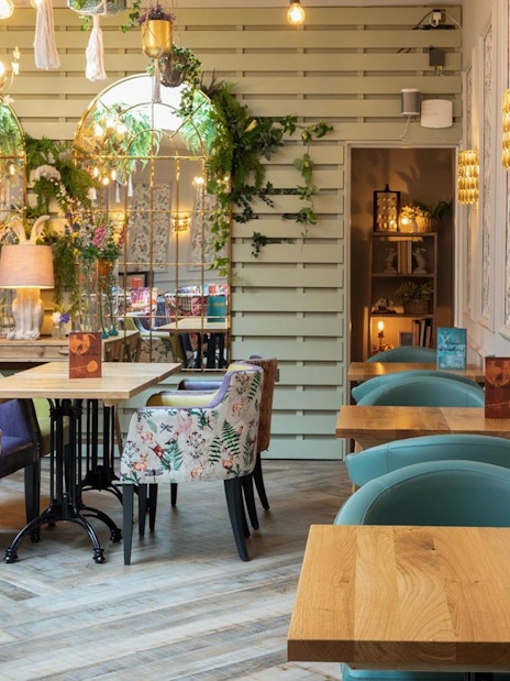 Lake District cruise boat on serene water with scenic hills, part of day tour from London including cream tea.