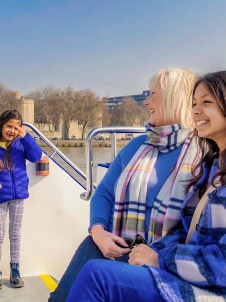 London Sightseeing Cruise passing by the historic Tower of London on a sunny day