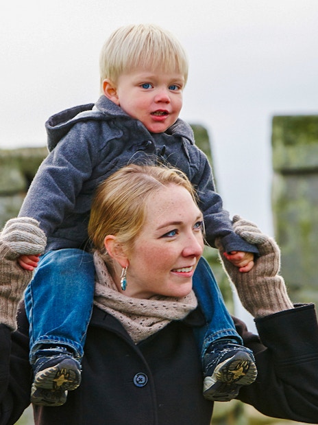 Visitors exploring Stonehenge with ancient stone formations in the background, England.