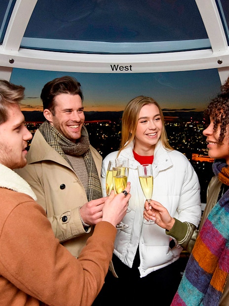 Group of tourists enjoying the London Eye Champagne Experience with a stunning view of the city skyline at sunset