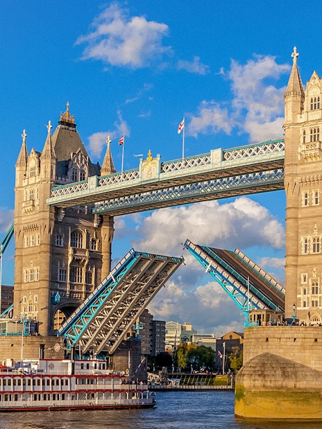 Tower Bridge in London with raised bascules, viewed from the River Thames.