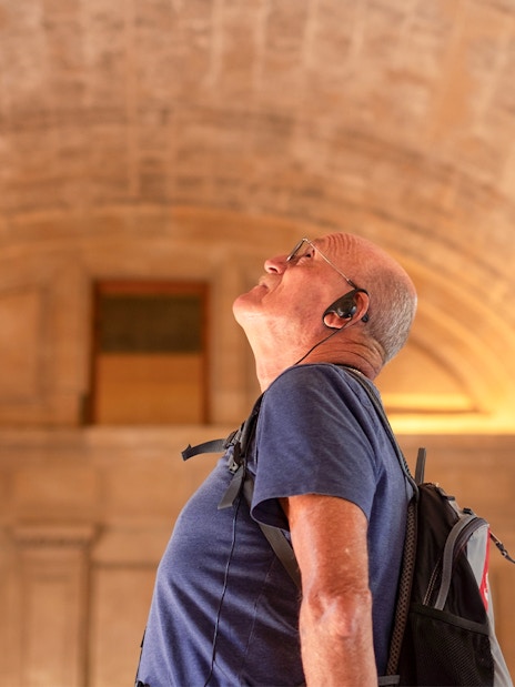 man listening to audio guide on the tour