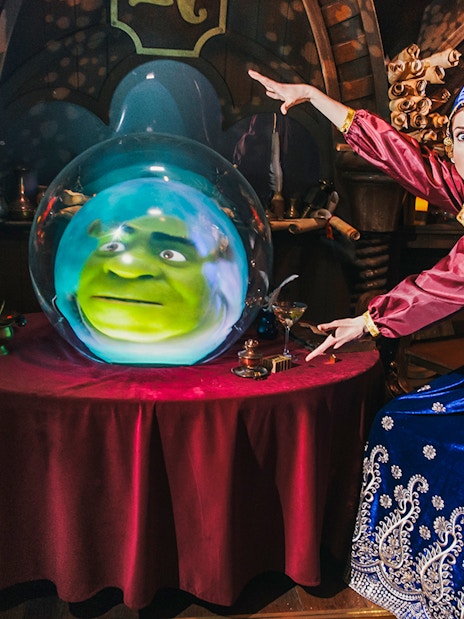 Visitors enjoying interactive Shrek's Adventure! London Tickets tour, featuring Shrek characters and London cityscape