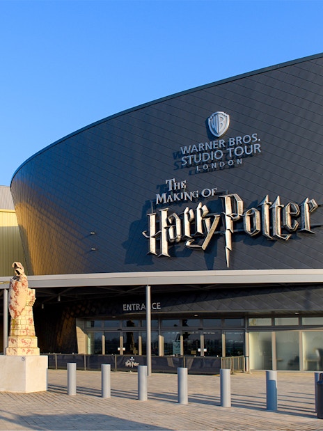 Warner Bros. Studio Tour London entrance with Harry Potter-themed decorations and visitors exploring.