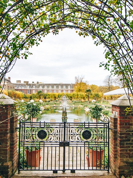 Kensington Palace royal gardens with manicured lawns and vibrant flowerbeds, London.