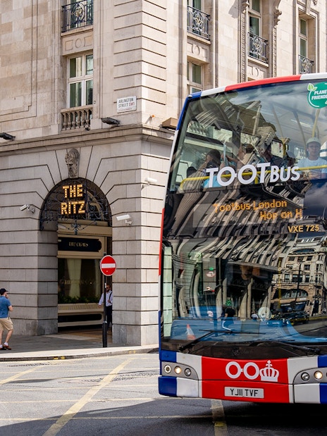 Tootbus touring London landmarks with passengers enjoying a Thames River Cruise.