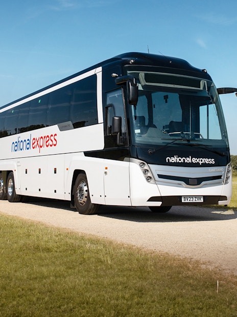 National Express bus traveling on a countryside road between Stansted Airport and London Victoria Station.