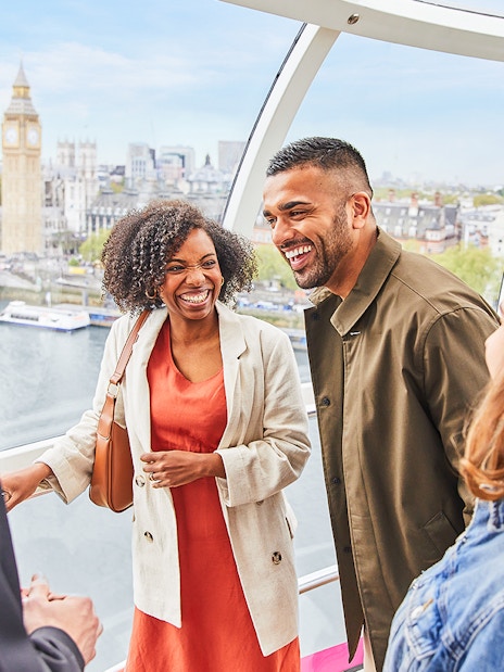London Eye capsule interior with passengers enjoying panoramic city views.