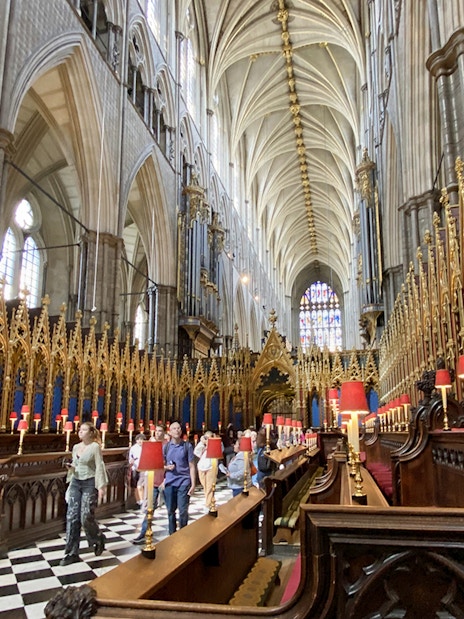 Tourist exploring Anglican Church interior at Westminster Abbey, London.